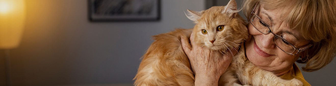Ältere Frau hält Katze im Arm